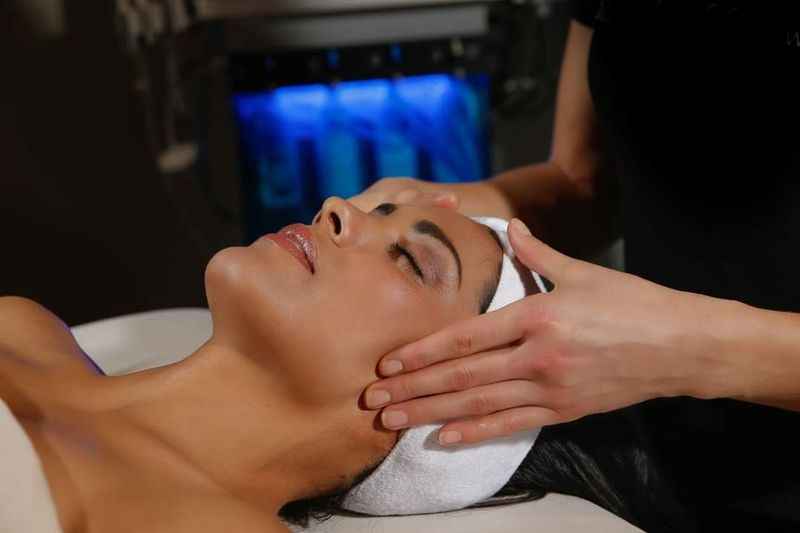 a woman getting a facial massage at a spa