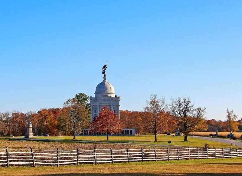 a monument surrounded by trees in autumn 