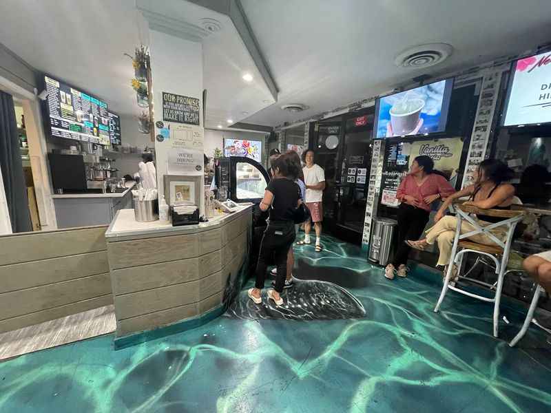 a woman is standing in a restaurant with a surfboard