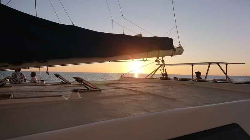 a boat with the sun setting in the background