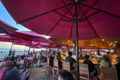 a group of people sitting at tables under umbrellas