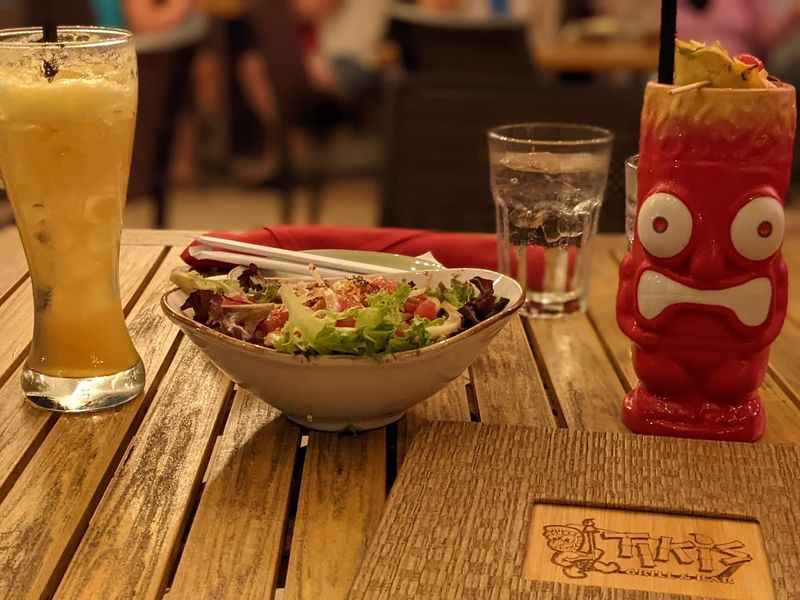 a bowl of salad and a drink on a table