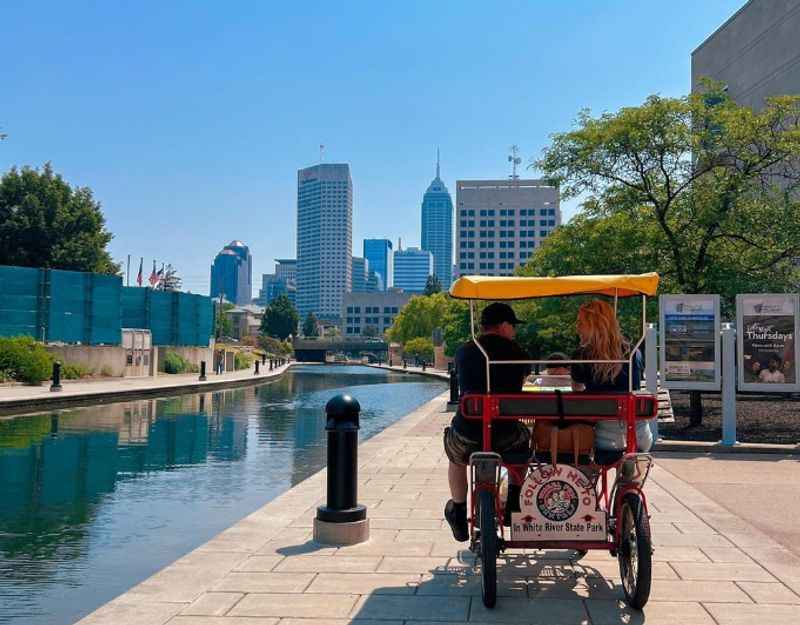 couples riding a bike down a river