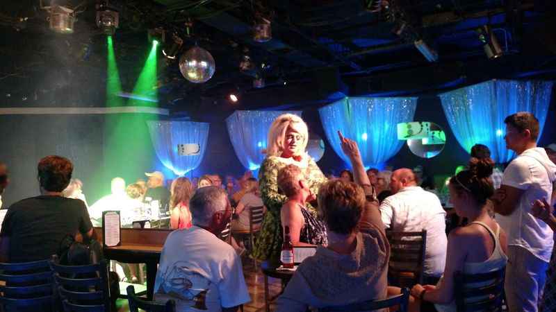 night club filled with man and woman sitted on the chairs