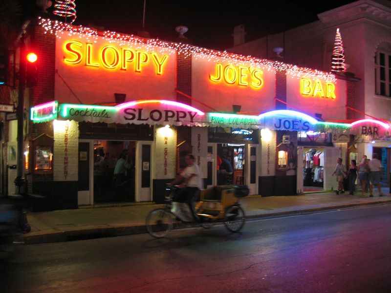 a sloppy signae with a neon lights at  night