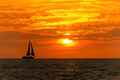 a sailer is sailing in the ocean at sunset