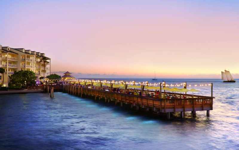 a pier with a boat in the water on a sunset