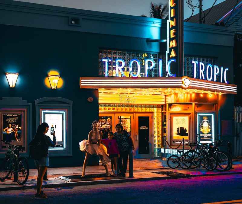 a group of people standing outside of a movie theater