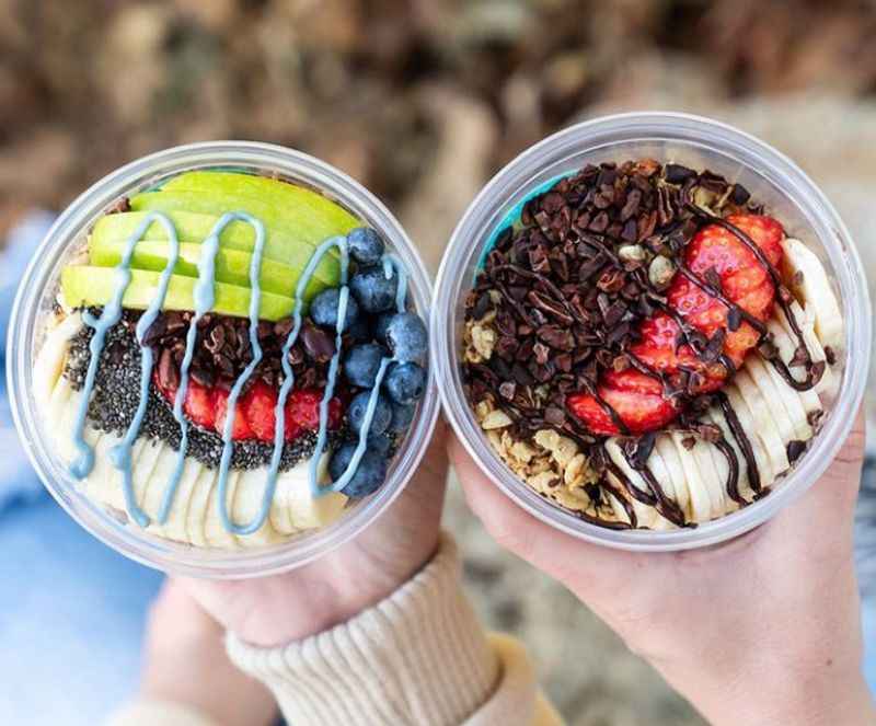 two people holding up two cups of food