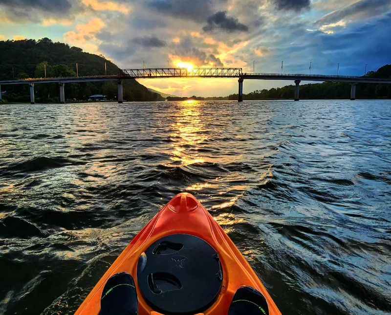 a kayak in the water with a bridge in the background