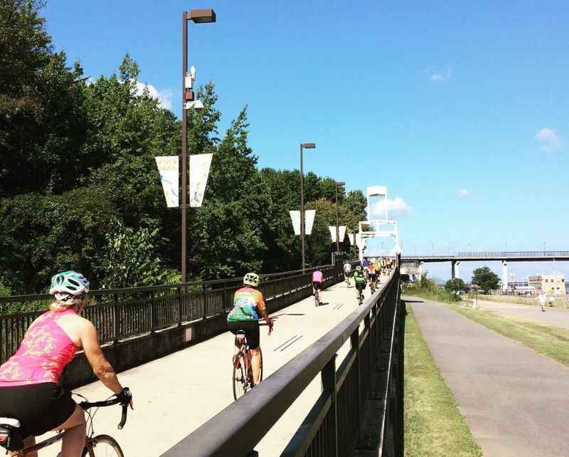 a group of people riding bikes on a bridge