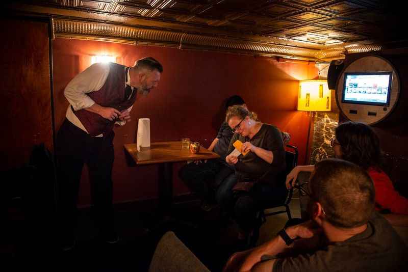 a group of people sitting around a table in a bar