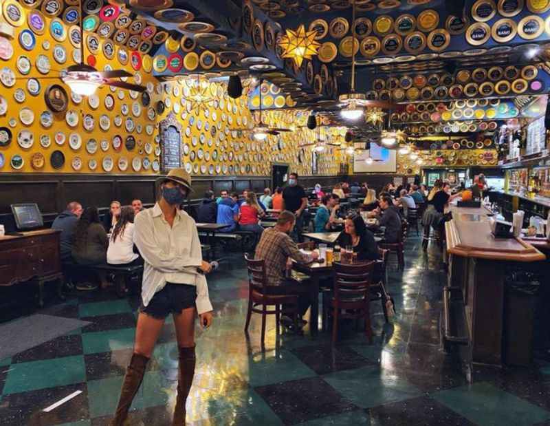 the interior of a restaurant with a large wall of plates on the ceiling