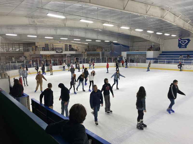 people skating on an ice rink in a building