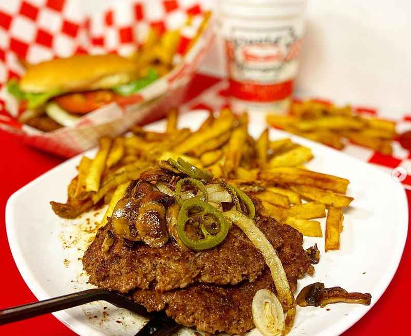 a plate of food with fries and a bottle of beer