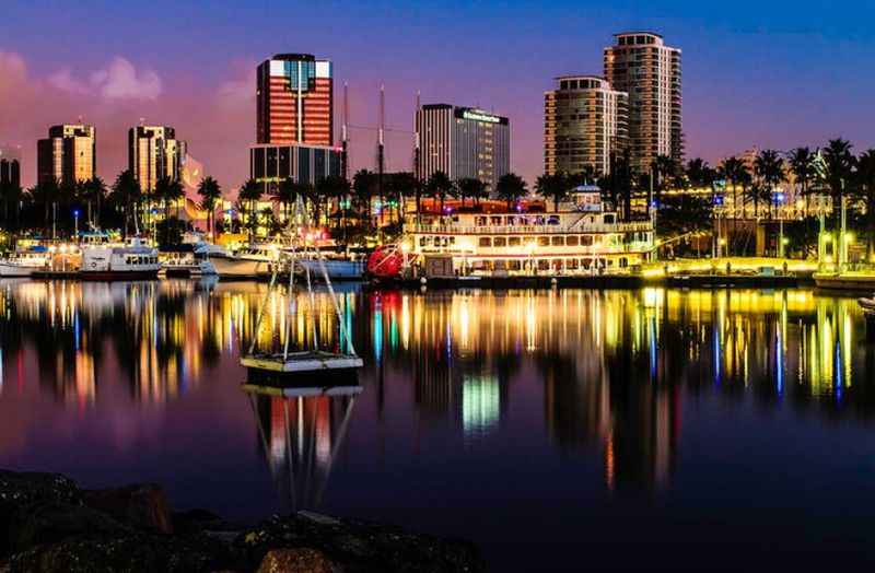 a city skyline at night with boats docked in the water