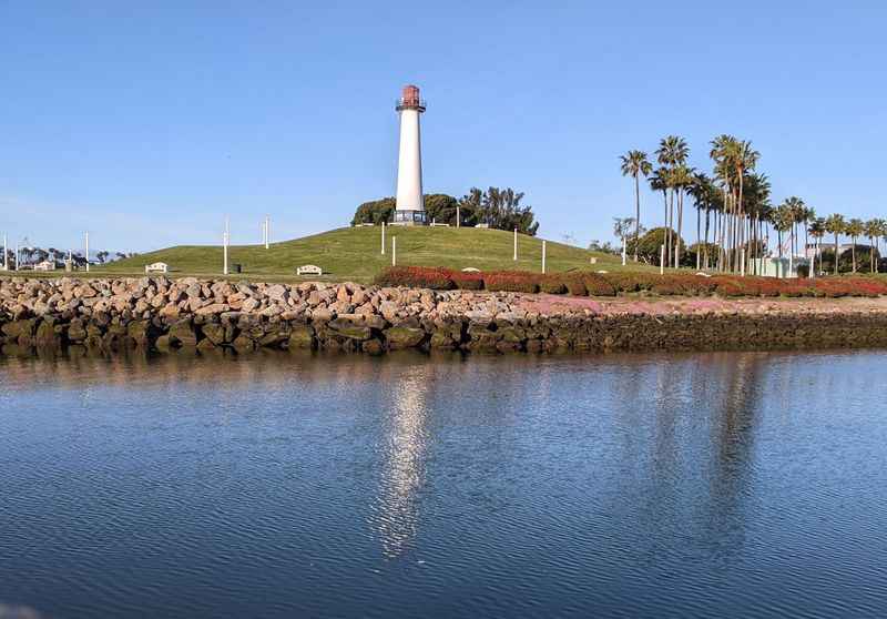 a lighthouse sits on the shore of a body of water