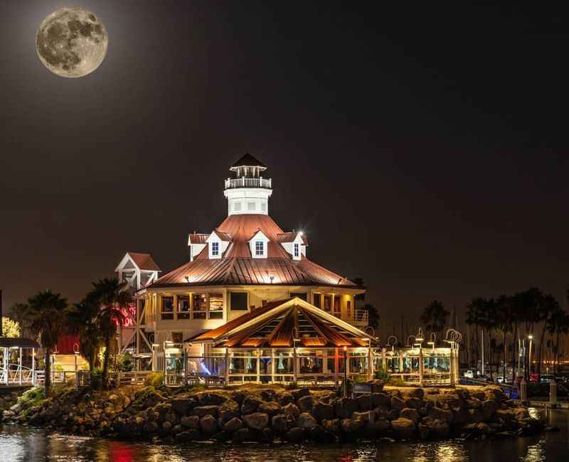 a full moon is seen over the lighthouse