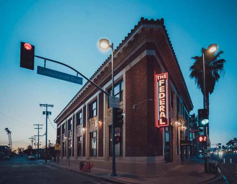 a red brick building with a neon sign on the front