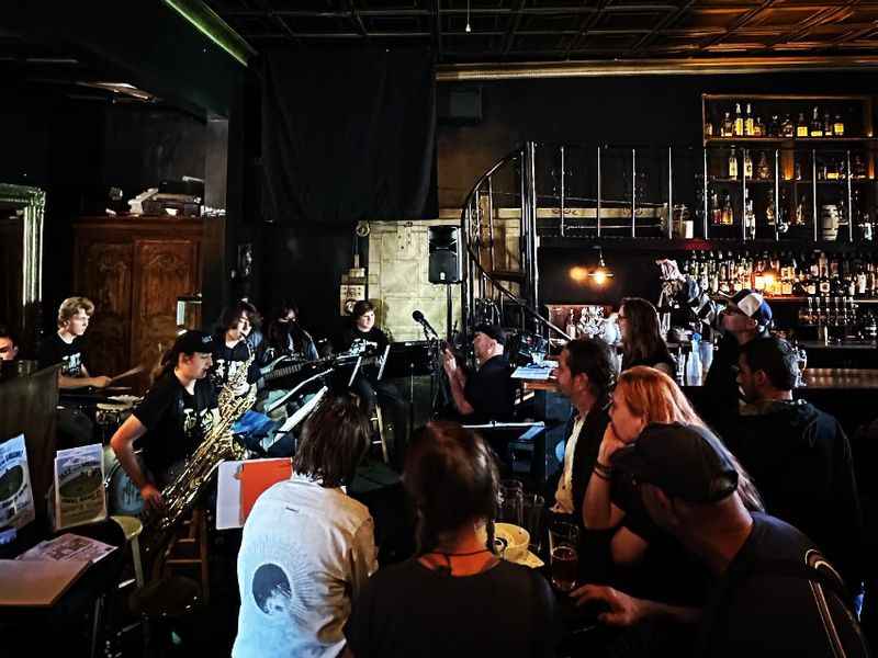 a band playing in a bar with a man on the stage