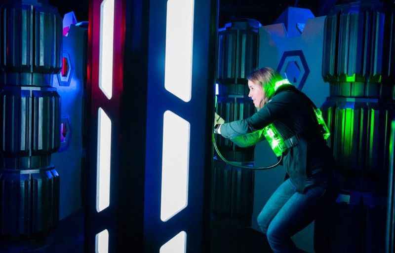 a woman in a room with in a laser game