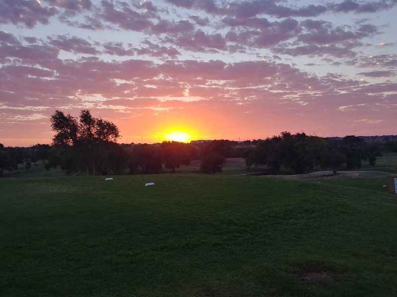 a sunset over a golf course