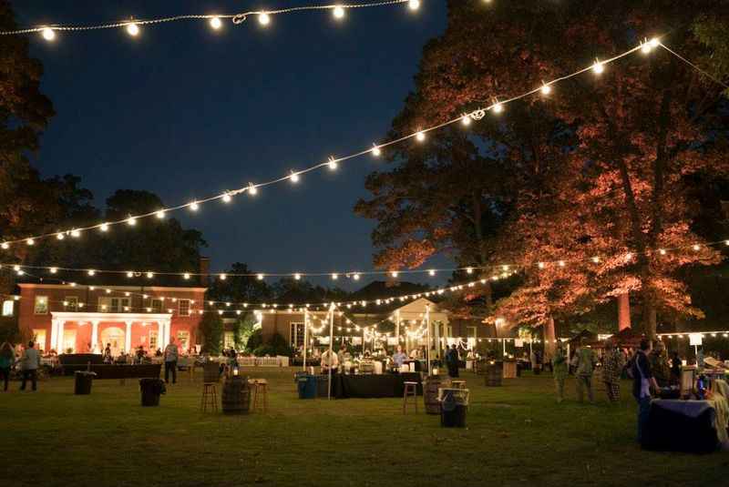 a garden with full of lights and tables and chairs