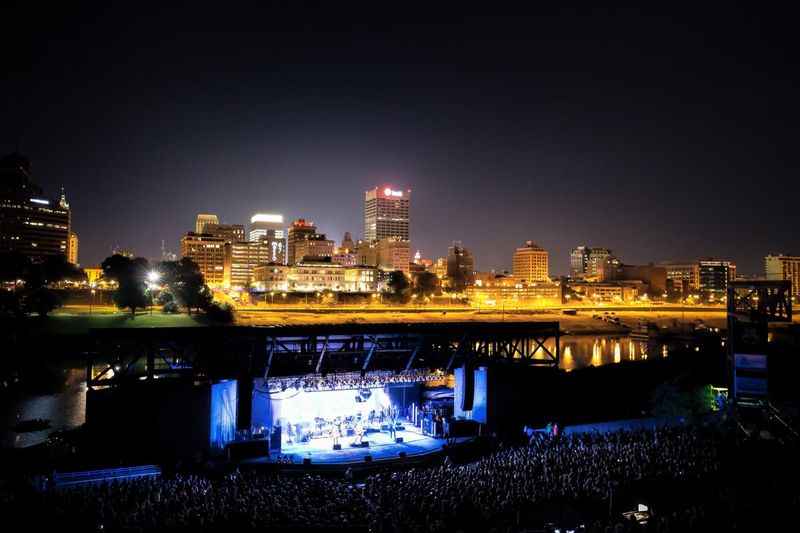 a concert on the river with a city skyline in the background