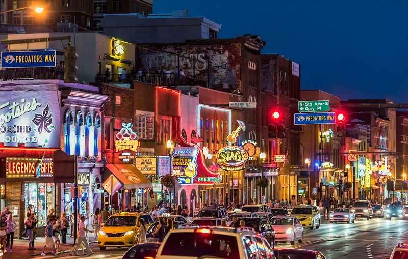 a city street filled with cars and neon signs