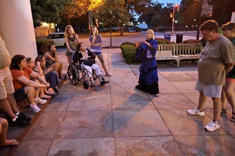 a group of people sitting on a sidewalk