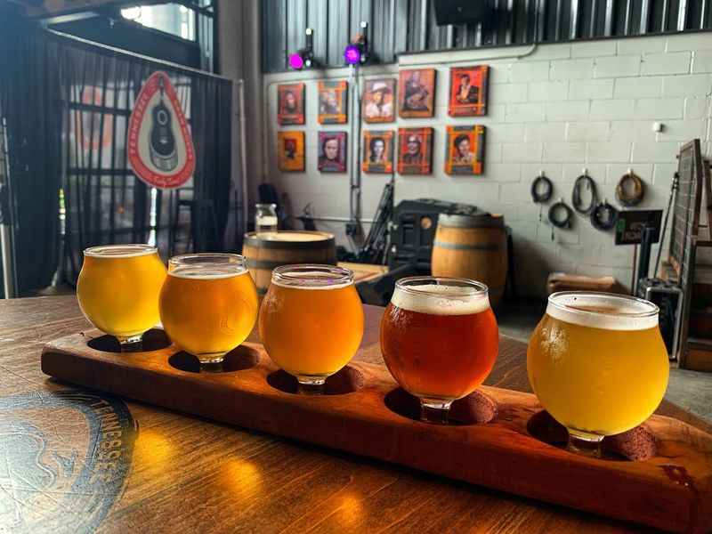 several glasses of beer lined up on a wooden tray