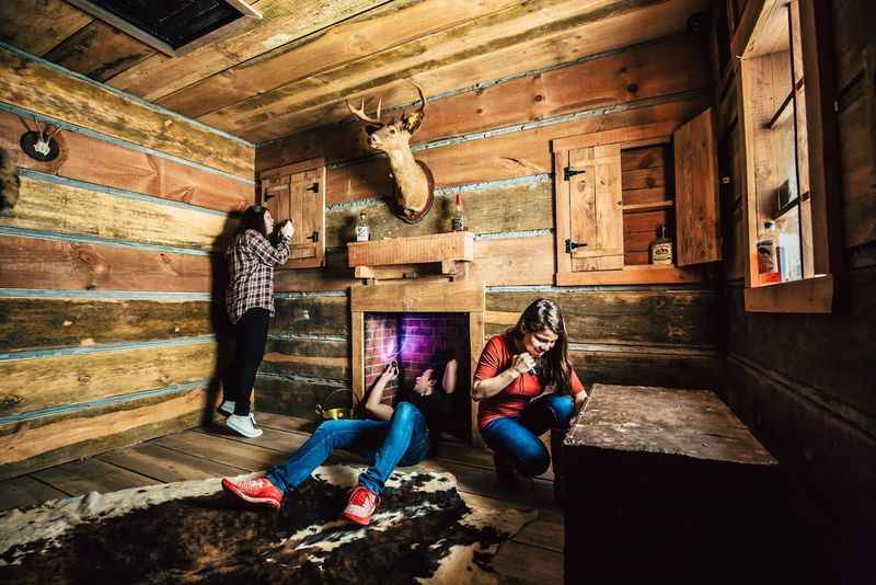 three people in a cabin with a fireplace