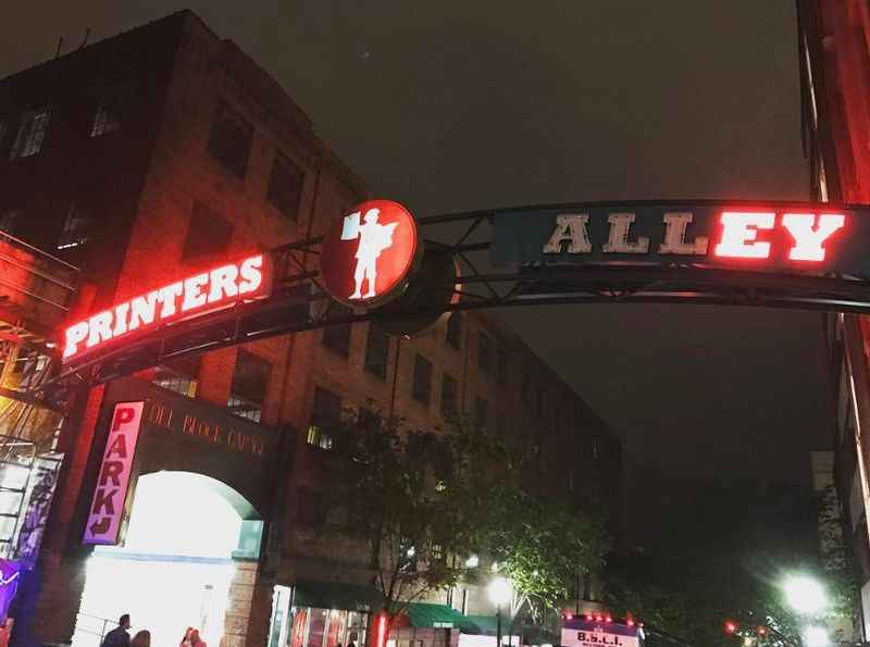 nighttime view of a city street with a neon sign 