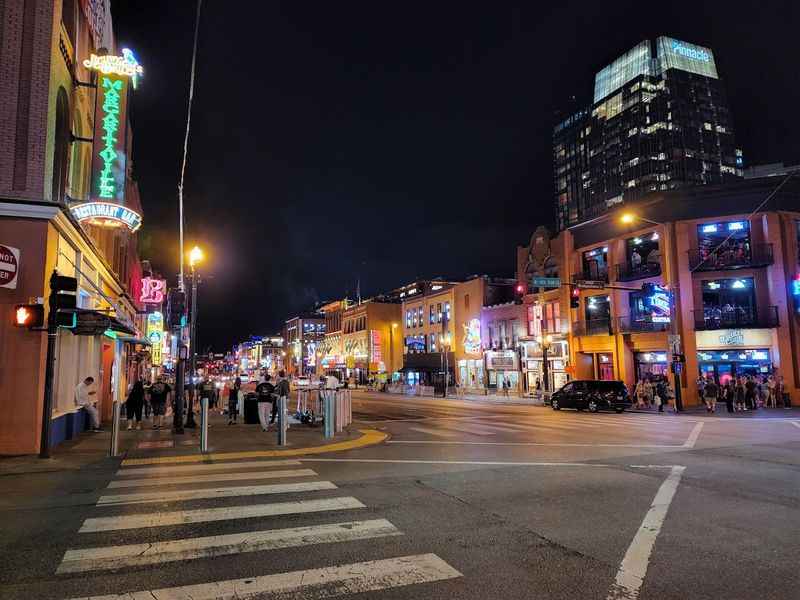 a street with people walking on it at night