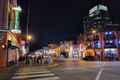 a street with people walking on it at night