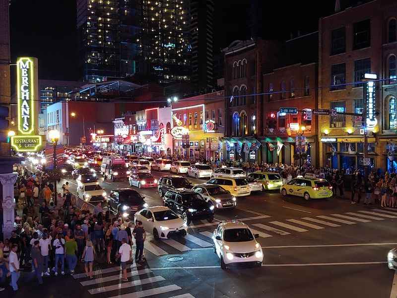 city street with cars and people at night