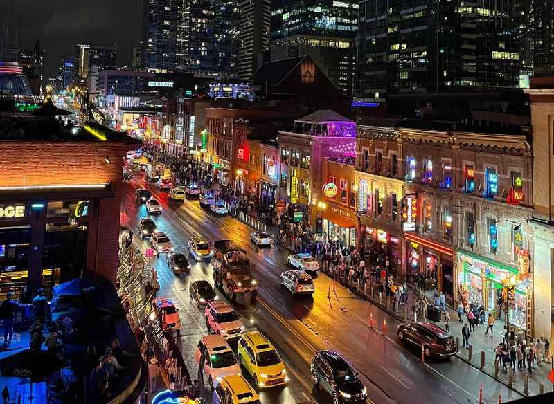 a city street with cars and people walking on it