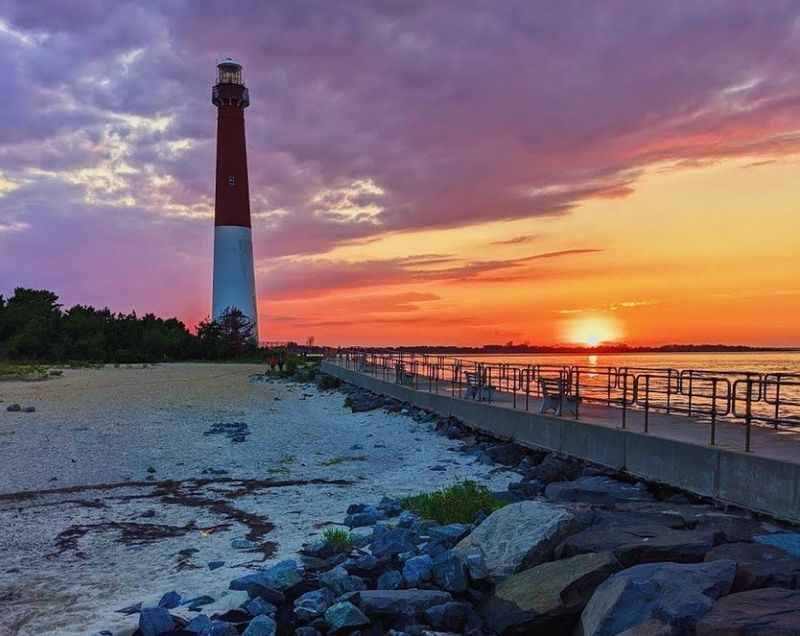 a lighthouse at sunset on the beach