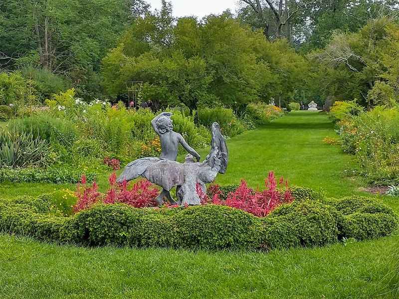 a statue of a man riding a horse in a garden