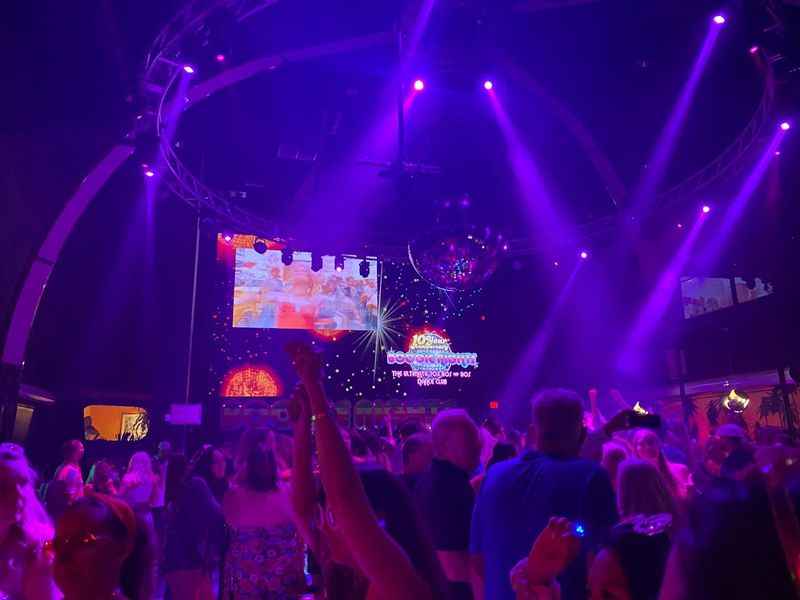 a crowd of people at a nightclub with purple lights