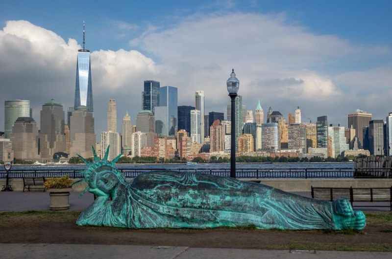 the statue of liberty in front of the new york skyline