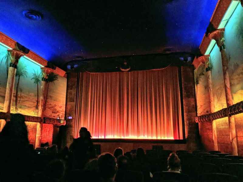 an orange stage curtain in the Grand Lake Theater