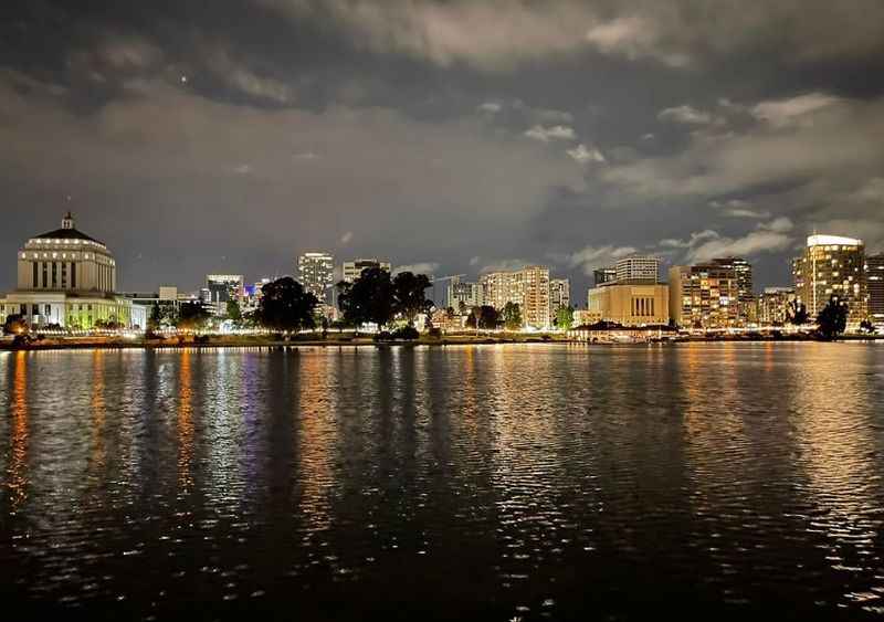 a city skyline at night with a lake in front