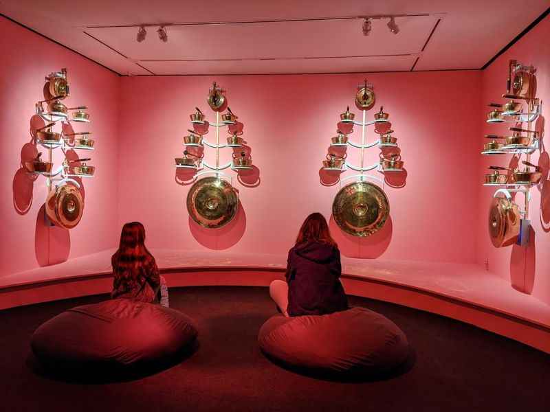 two women sitting on bean bags in a pink room