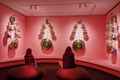 two women sitting on bean bags in a pink room