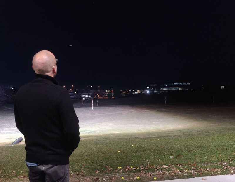 a man standing on a sidewalk at night