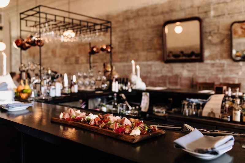 a bar with a wooden table and tray with food on it