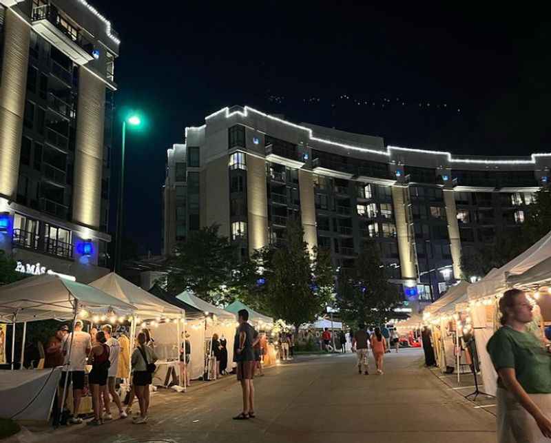 a crowd of people walking around a street at night