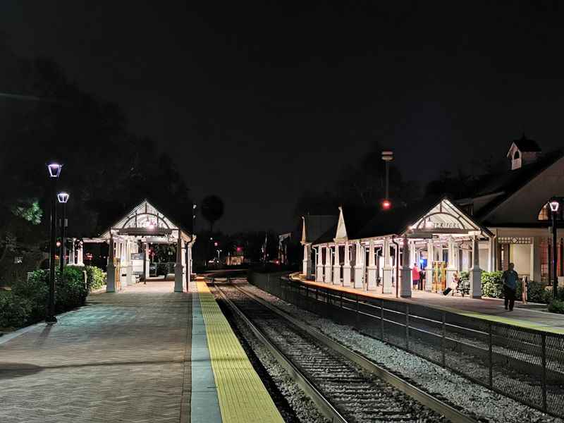 a train station at night with a train on the tracks