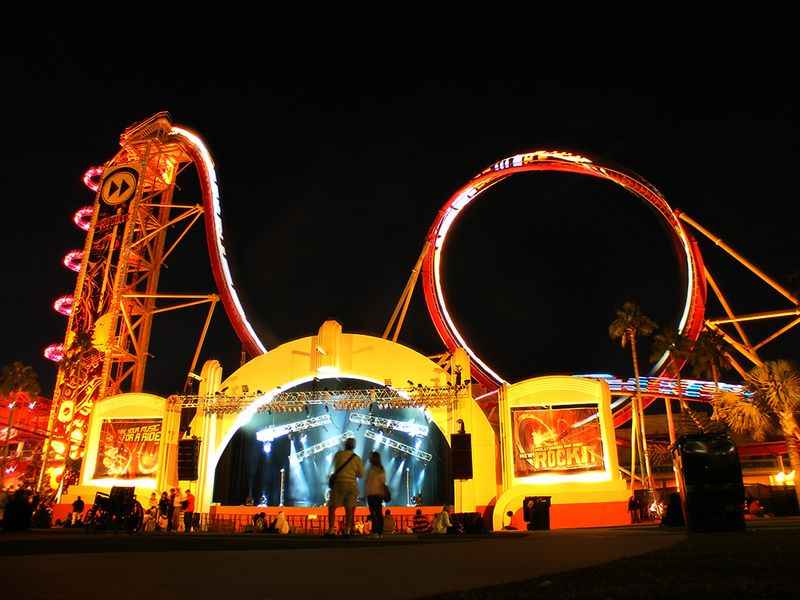 a large roller coaster with red lights at night